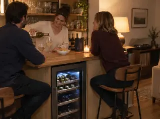 Une femme sert des amis à un coin bar de séjour, une cave à vin à deux zones sous le comptoir du bar