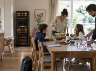 Repas de midi en famille, enfants à table, une cave à vin à deux zones contre le mur de la salle à manger