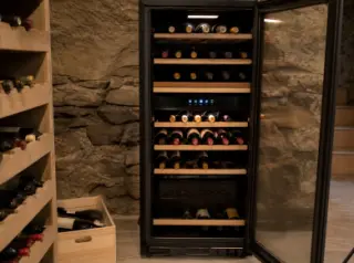 Modern electric wine aging cabinet open in a stylish apartment, showcasing neatly arranged bottles, LED lighting, and digital controls for temperature and humidity.
